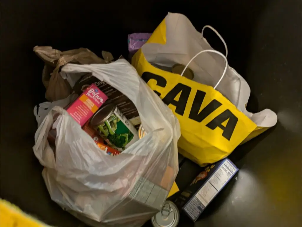 Image of food and hygiene products in a yellow barrel at the UPS CSS Department Food and Hygiene Drive for Ministries of Grace.