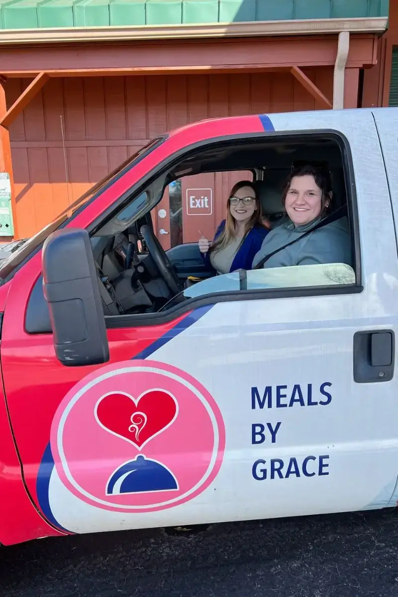 Image of two Ministries of Grace volunteers in the Meals By Grace truck on their way to deliver food to a hungry family in Northern Georgia.