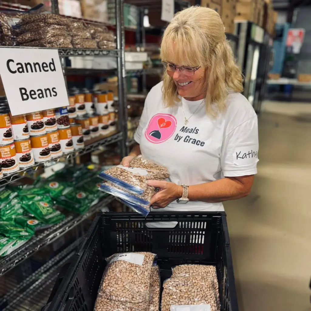 Image of a Ministries of Grace volunteer packing a food box for a food-insecure family in Georgia. The image is used the the article about Top Christian Nonprofits that serve in Georgia.