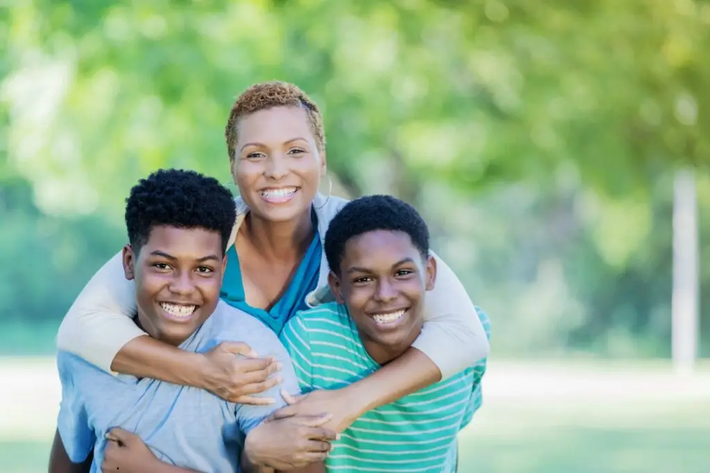 Image of a single mom with her two teenage sons representing how monthly giving helps single parent families in Georgia.