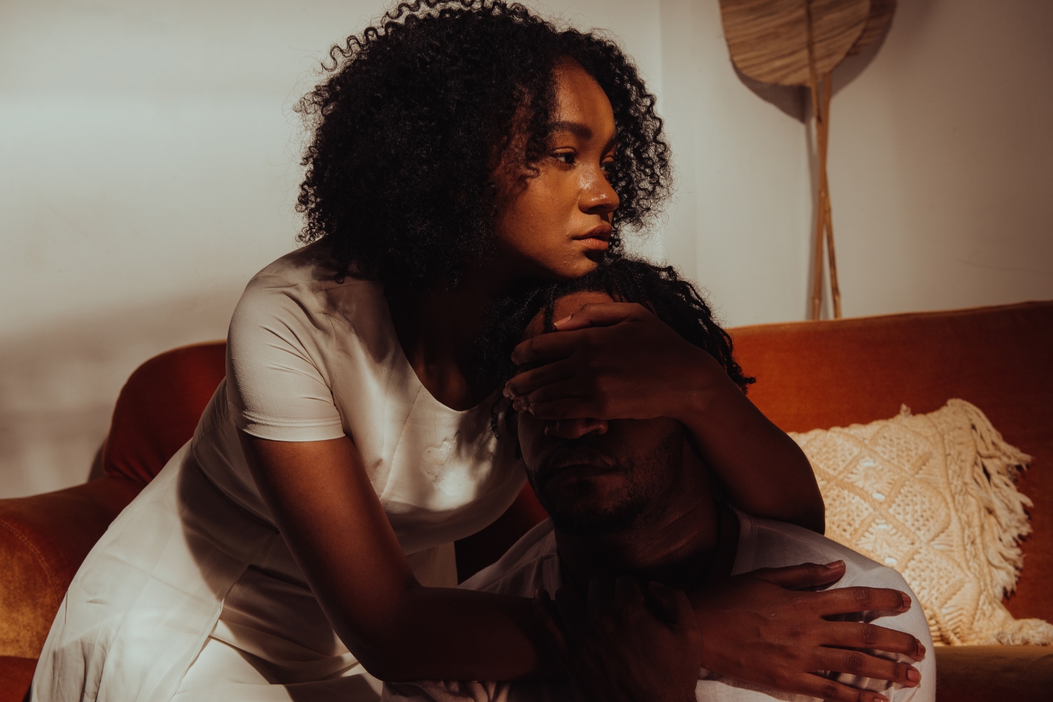Image of a mom in an apartment hugging her daughter while staring off into space representing the mental health support that Ministries of Grace offers its families.