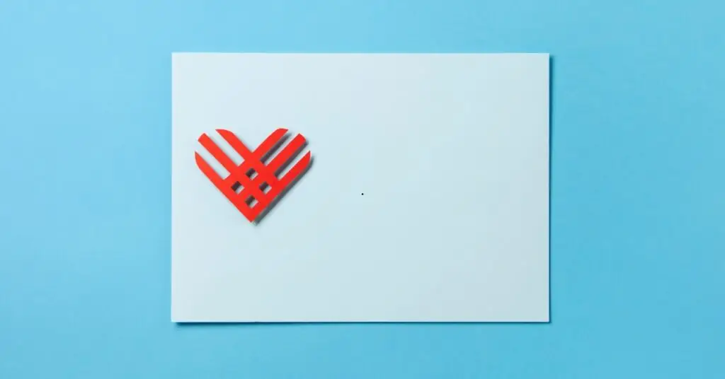 Image of a white envelope with a read heart on it over a blue background representing Giving Tuesday, a global day of generosity with a local impact.